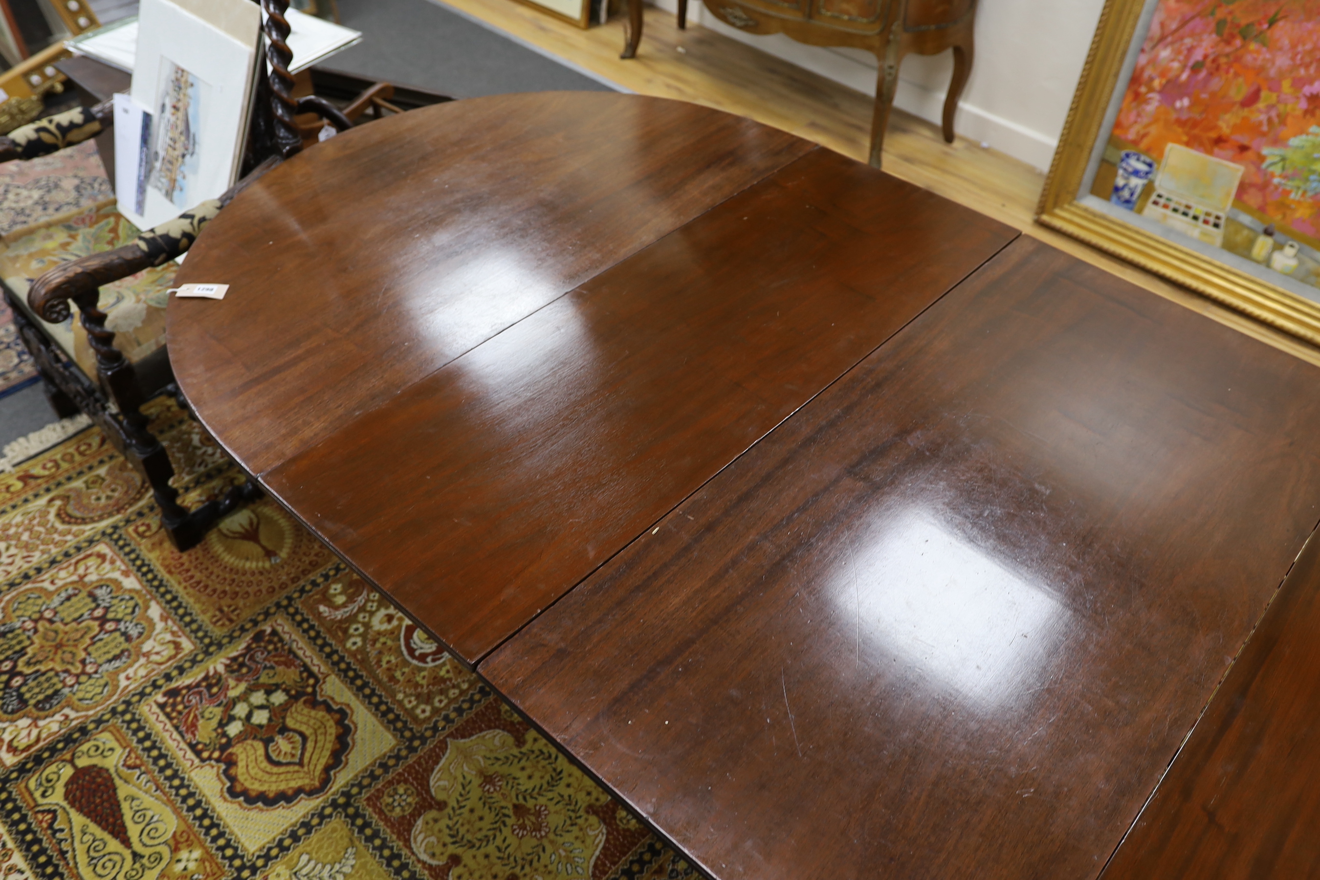 A George III style mahogany triple pillar D end extending dining table in the manner of Gillows